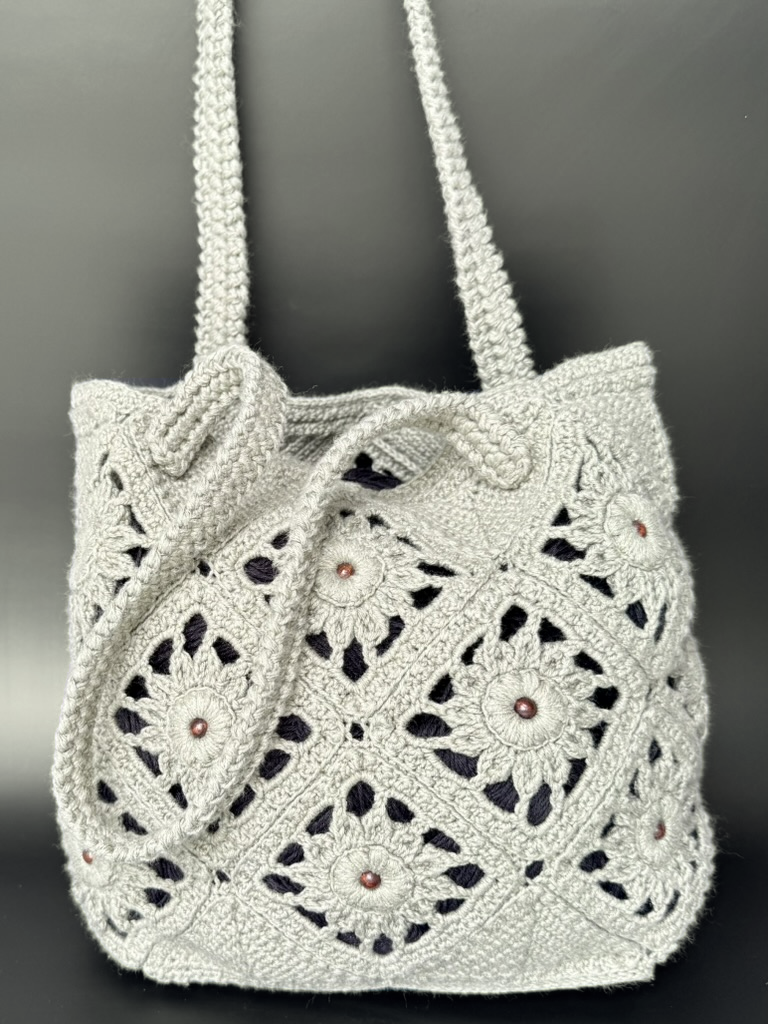 BLÓMI crochet bag against a dark grey background